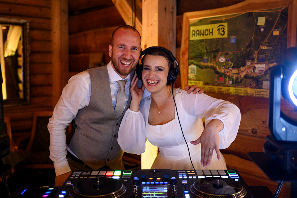 Nevesta so slúchadlami za DJ pultom pózuje spolu so ženíchom.
