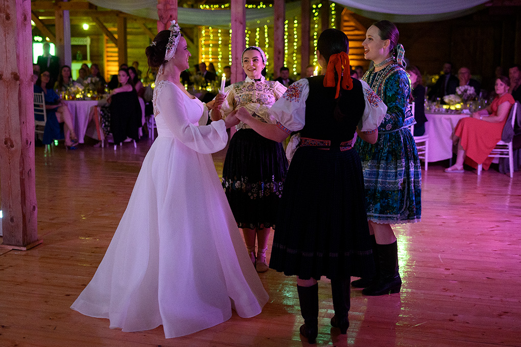 Nevesta tancuje s členkami folklórneho súboru počas odčepčenia v stodole Ranch 13.