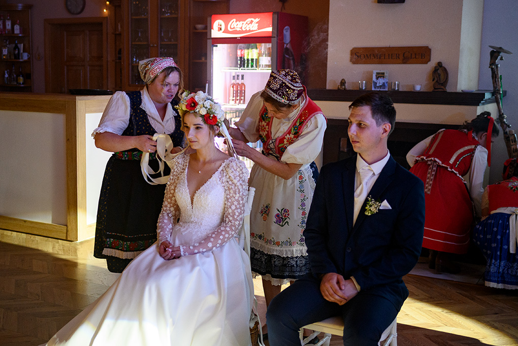 Členky folklórneho súboru skladajú neveste svadobný veniec z hlavy.