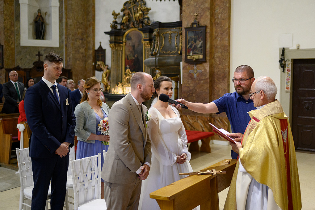 Ženích prednáša svadobný sľub pred kňazom počas cirkevného obradu.