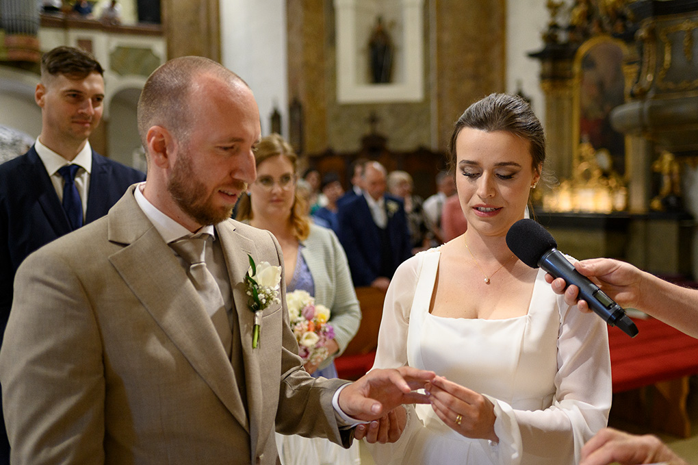 Nevesta navlieka ženíchovi obrúčku počas svadobného obradu.