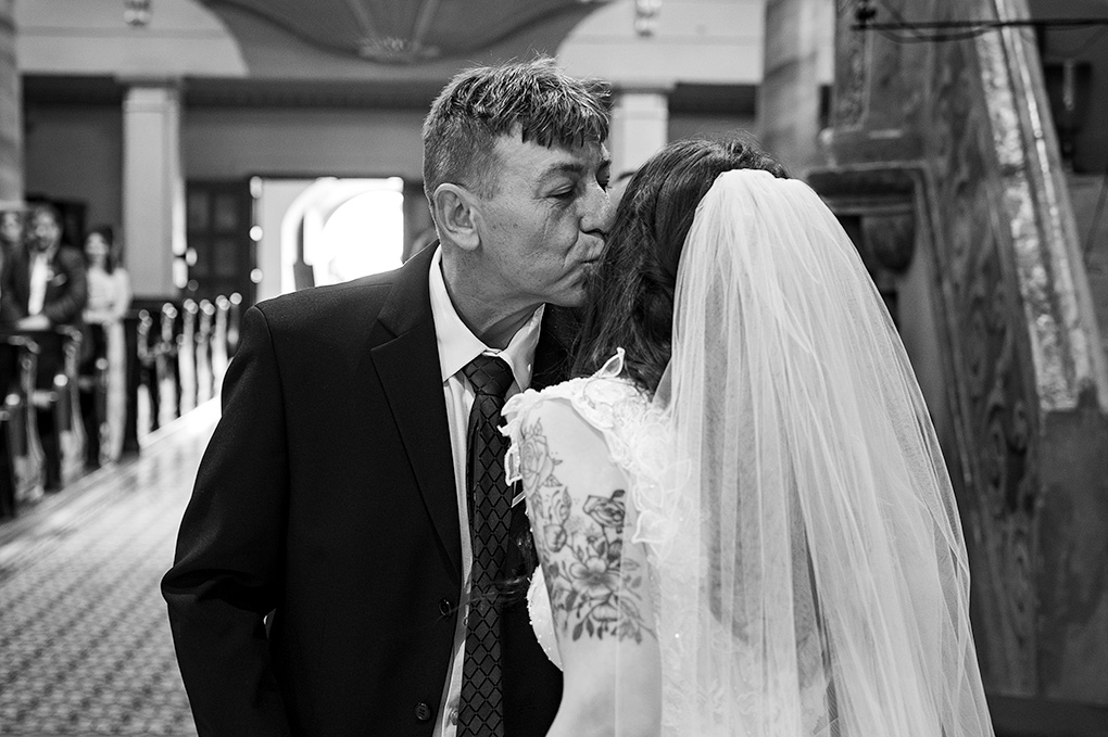 Otec bozkáva dcéru na čelo pri odovzdávaní ženíchovi.