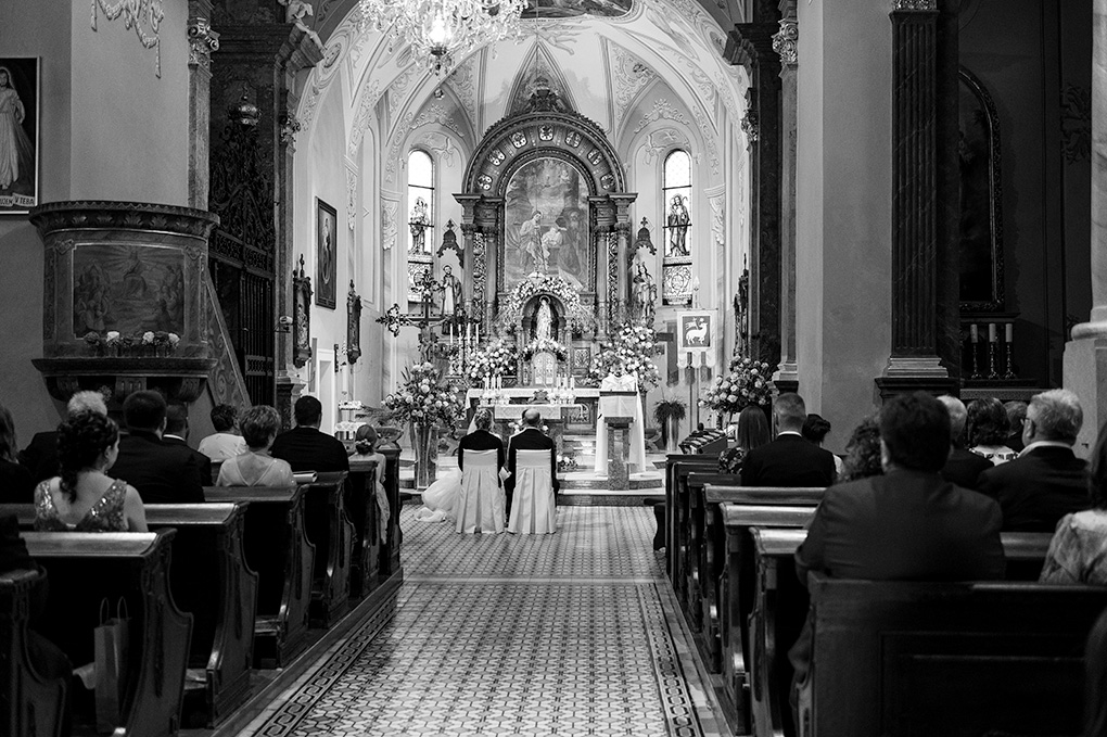 Svadobní hostia v laviciach Farského kostola v Trenčíne.