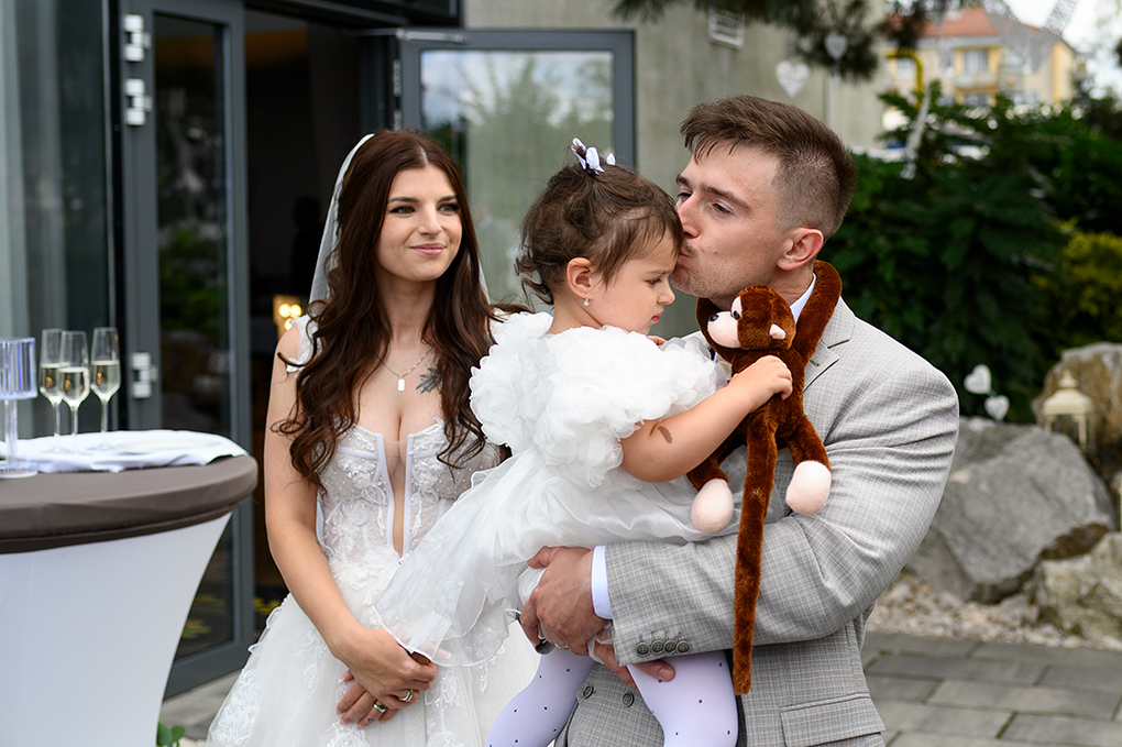 Ženích bozkáva dcéru pred vstupom na hostinu.