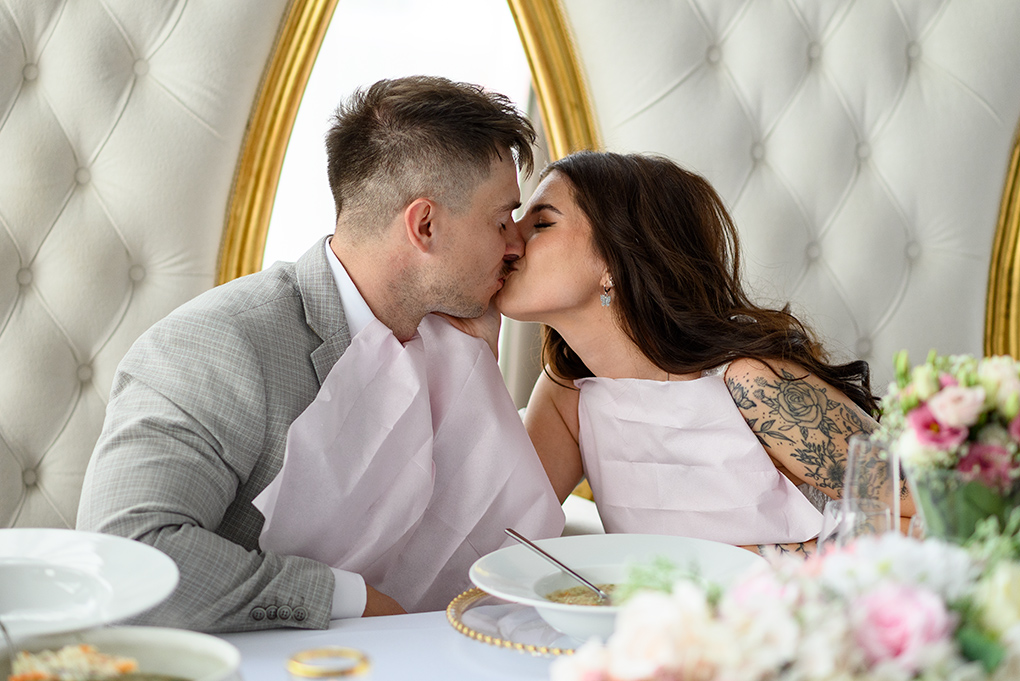 Bozk páru počas spoločného obeda v sále.