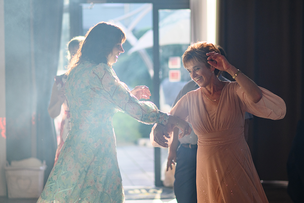 Tanec hostí pod svetelnými efektmi na hostine.