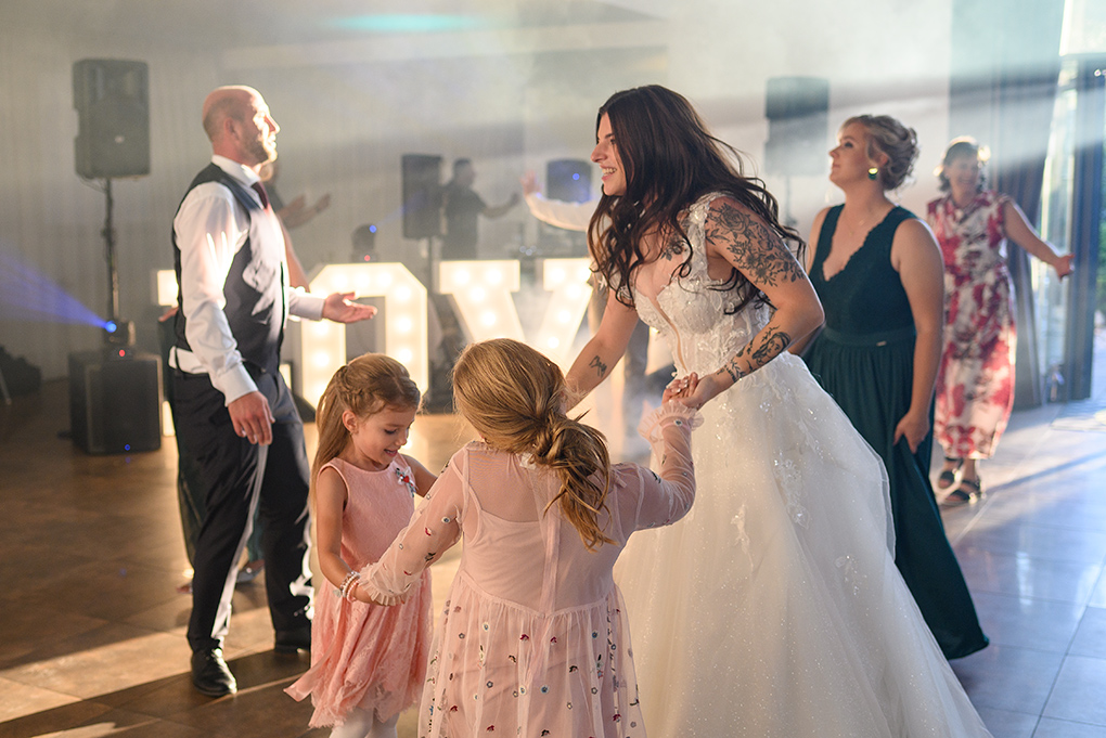 Nevesta s družičkami pred svietiacim nápisom LOVE.