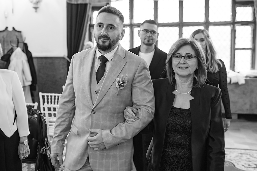 Ženích pri oltári Ženích kráča k oltáru v sprievode matky.