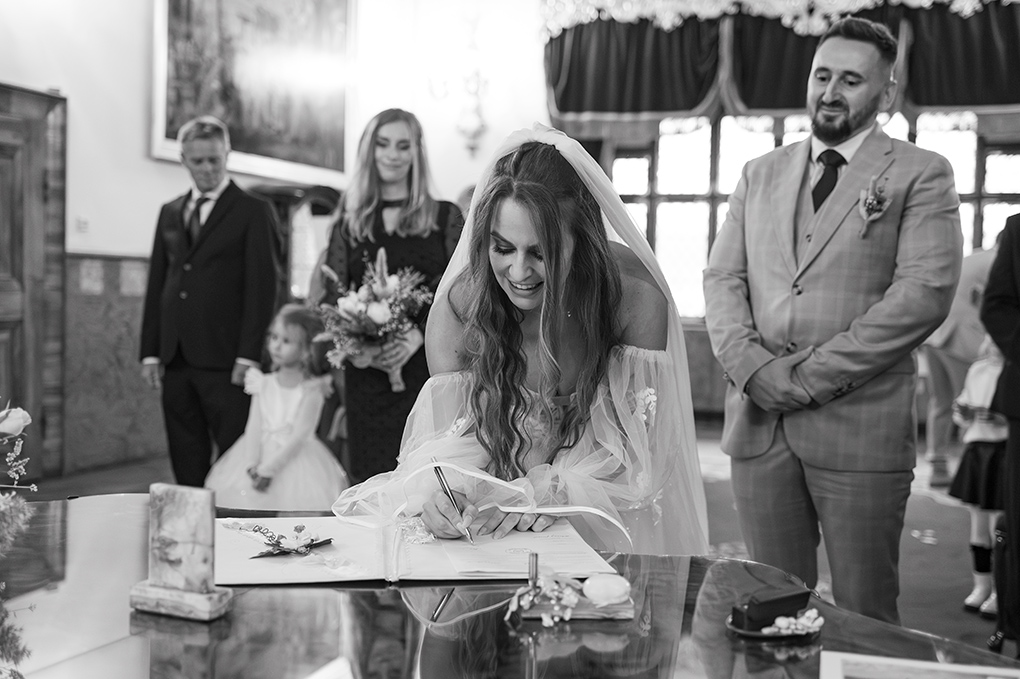 Podpis nevesty Nevesta podpisuje svadobnú zápisnicu po obrade.