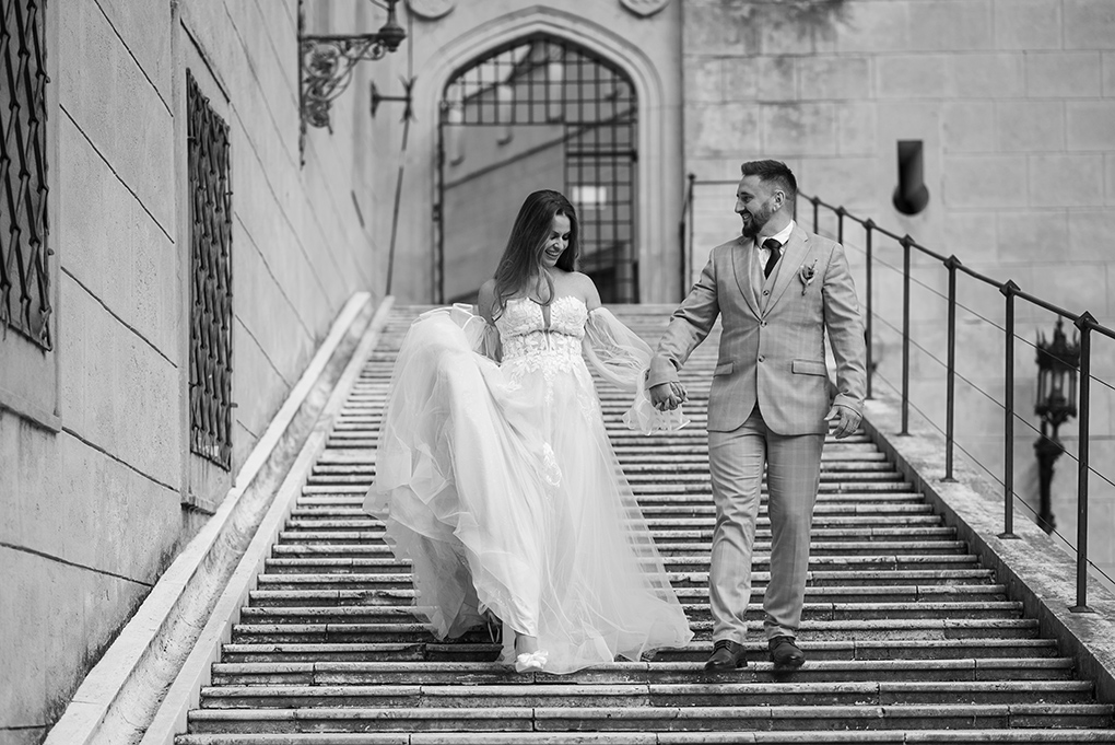 Mladomanželia na schodoch Novomanželia schádzajú po schodisku v exteriéri zámku v Bojniciach.