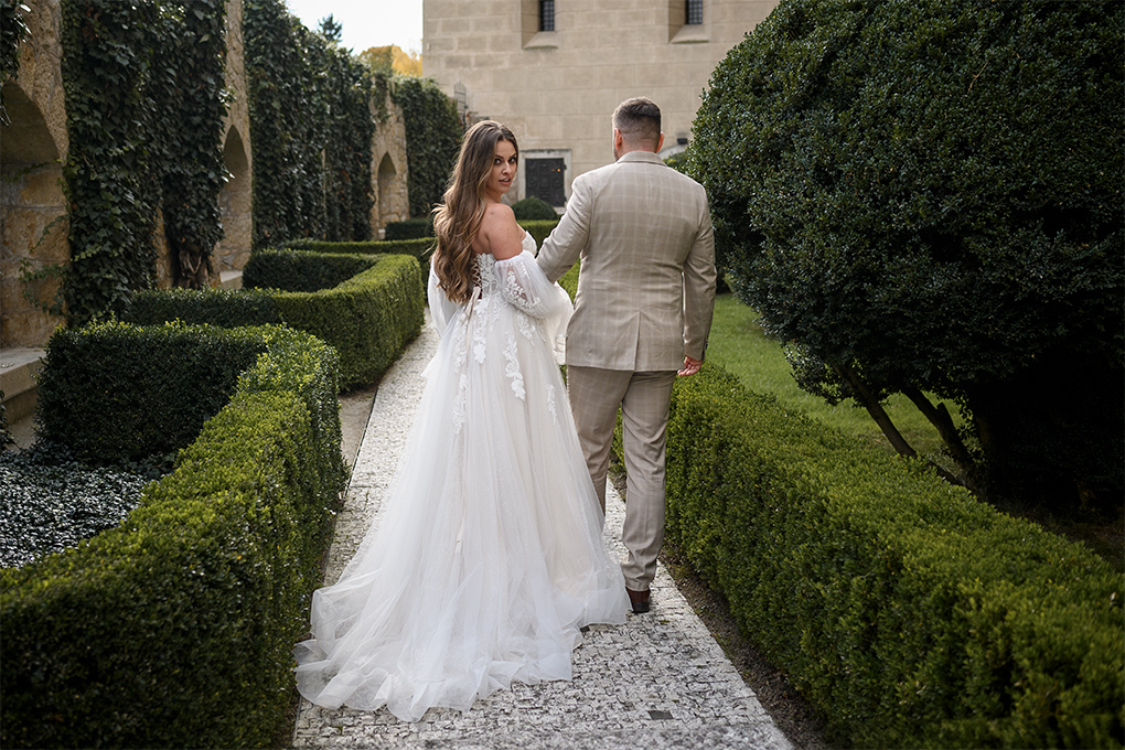 Prechádzka v záhrade Pár kráča po kamennom chodníku v záhrade.