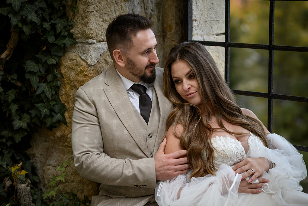 Pár pri múre Novomanželia pri kamennom múre s výhľadom na okolie.