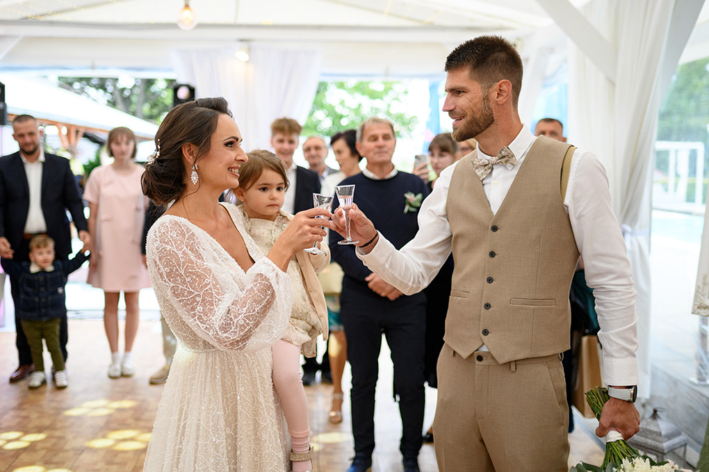 Novomanželia si pripíjajú s hosťami počas privítania na hostine v Kerkira Pub Veľké Úľany.