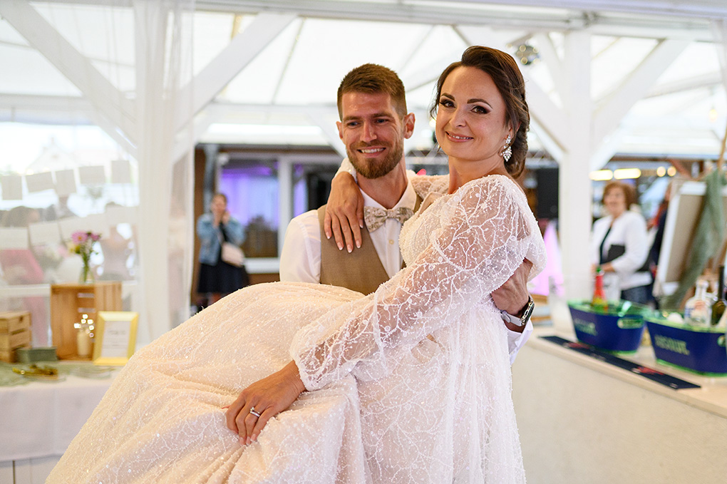 Šťastný svadobný pár v objatí počas svadobnej hostiny vo Veľkých Úľanoch.