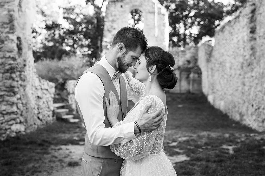 Romantické čiernobiele objatie novomanželov v historických priestoroch kláštora.