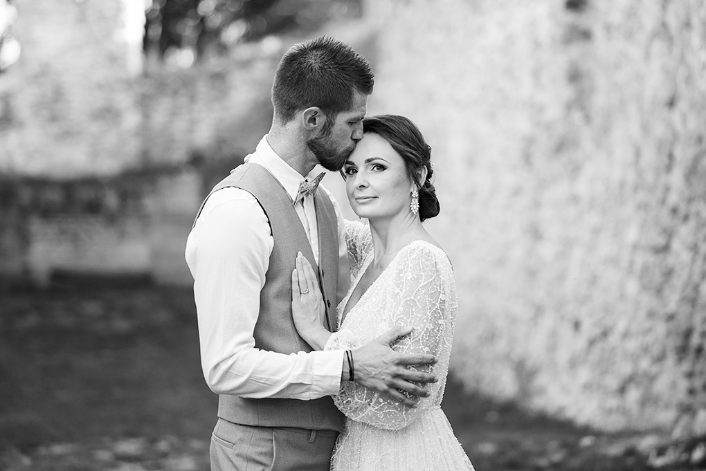 Ženích nežne bozkáva nevestu na čelo, svadobné fotenie v zrúcanine Katarínka.
