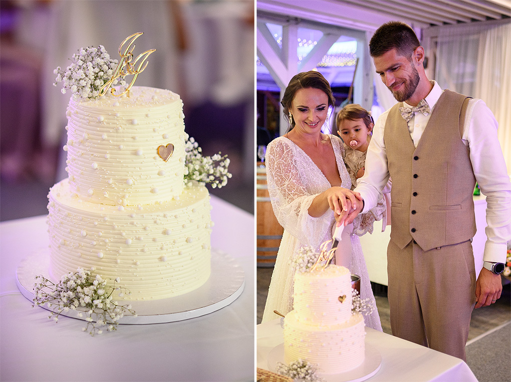 Mladomanželia s dcérkou spoločne krájajú svadobnú tortu v slávnostne vyzdobenej sále.