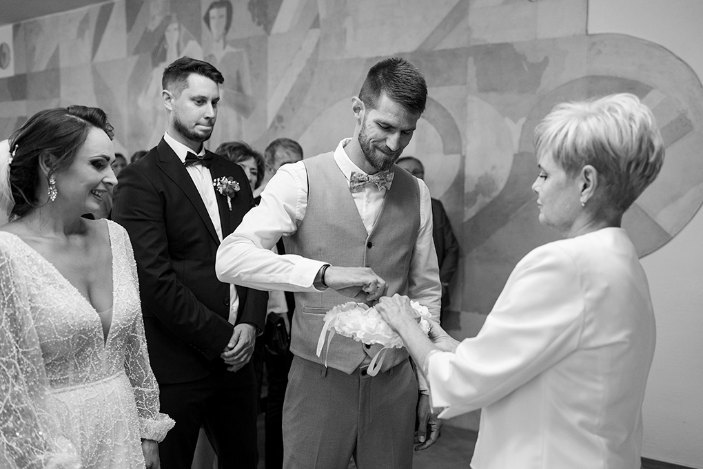 Detailný záber na ruky nevesty a ženícha pri navliekaní svadobných obrúčok.