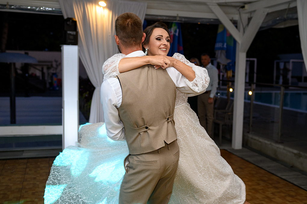 Nevesta a ženích v tesnom objatí počas tanca na ich svadobnej hostine.