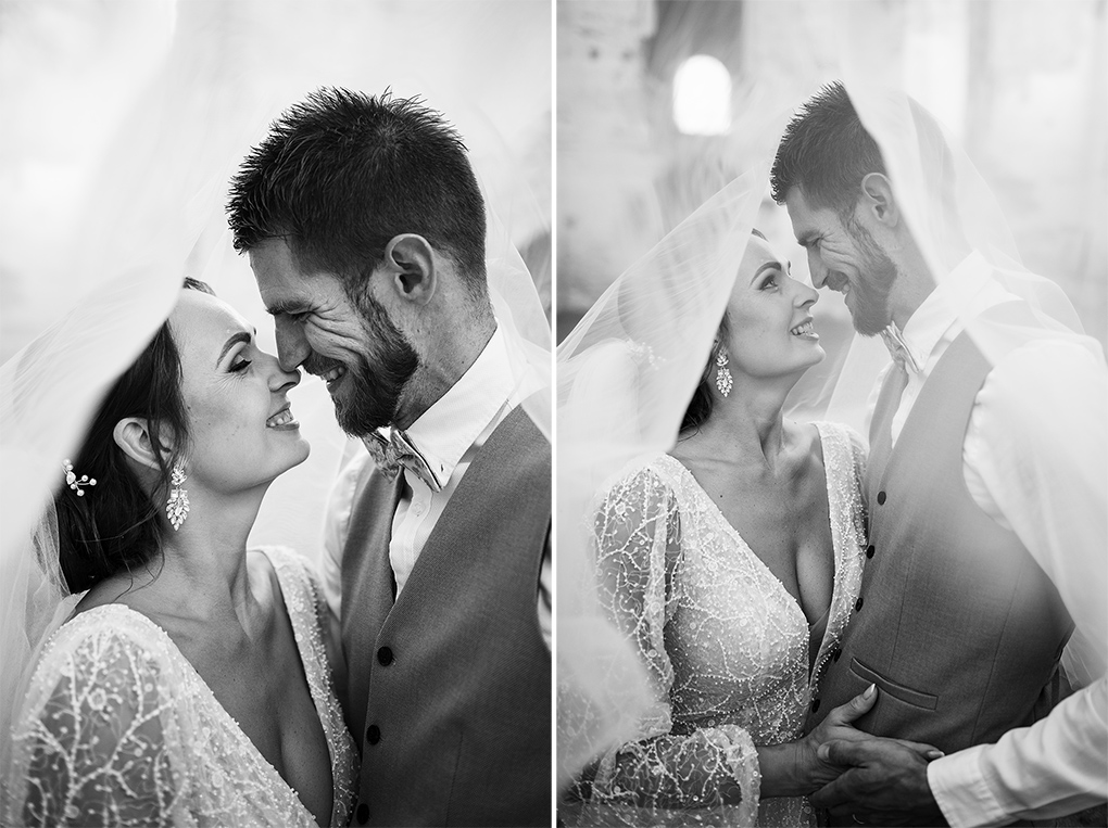 Umelecký čiernobiely detailný záber novomanželov cez svadobný závoj.