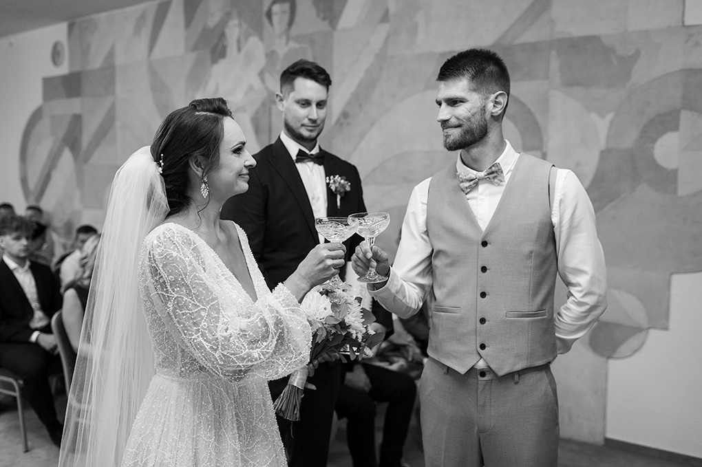 Novomanželia si štrngajú pohármi na úvod gratulácií po obrade.