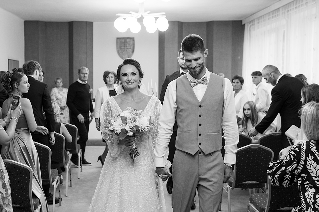 Čiernobiely záber na mladomanželov po skončení obradu